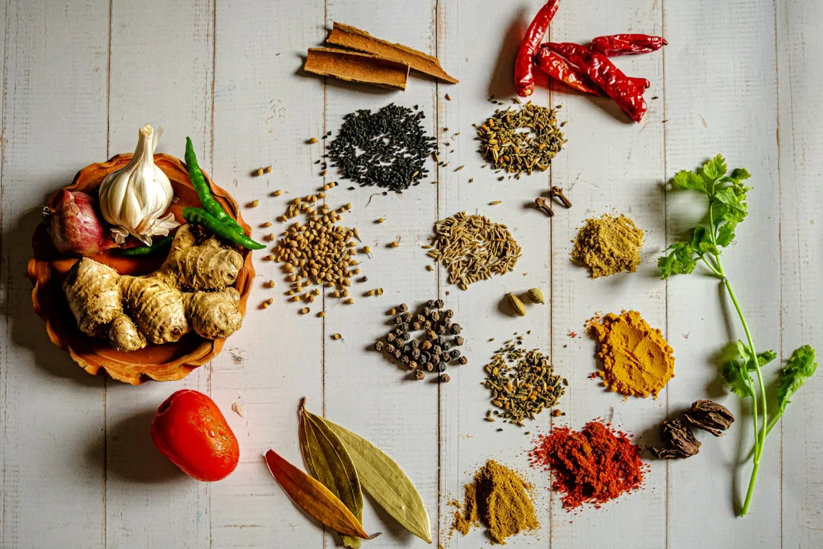 Whole and ground spices arranged on a work surface